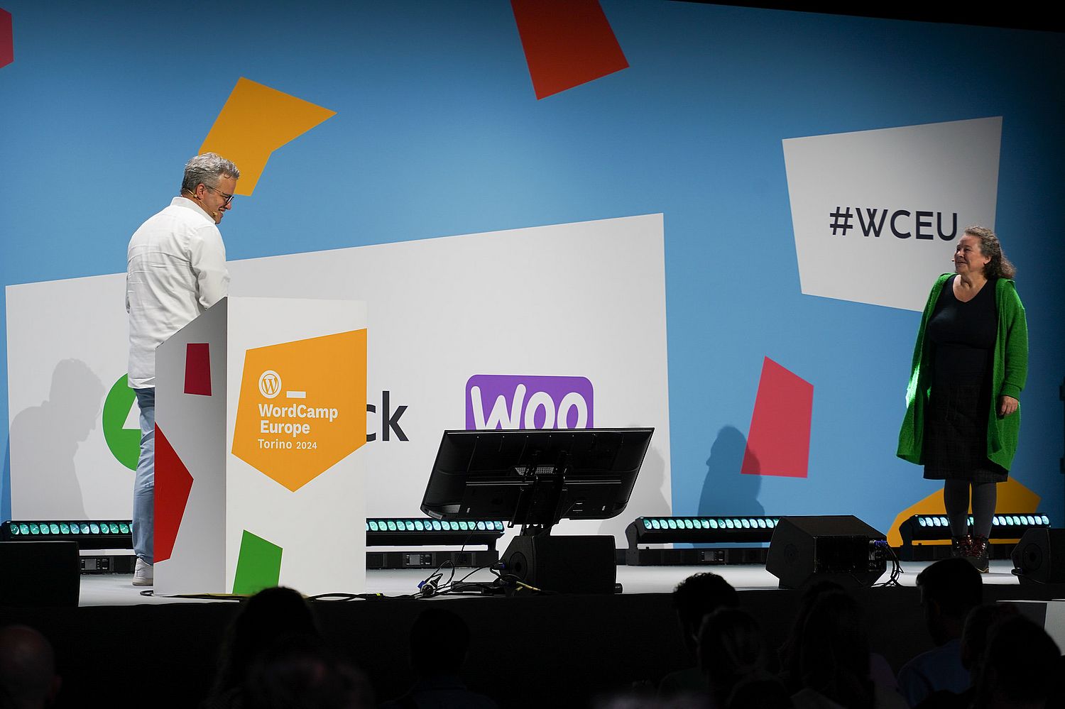 A man and a woman on a conference stage.