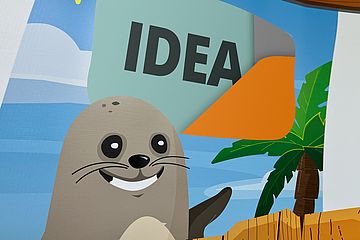 A cartoon seal in a tropical environment. The word "idea" above its head.