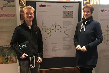 Two people standing in front of an information poster.
