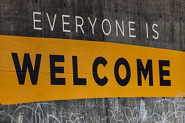 "Everyone is Welcome" painted on a wall.