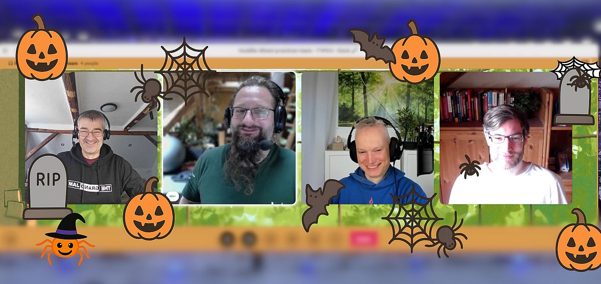 Screenshot of a video call with four smiling people, decorated with cartoon Halloween pumpkins, spiders, spiderwebs, bats, a tombstone, and a witch hat around the edges.