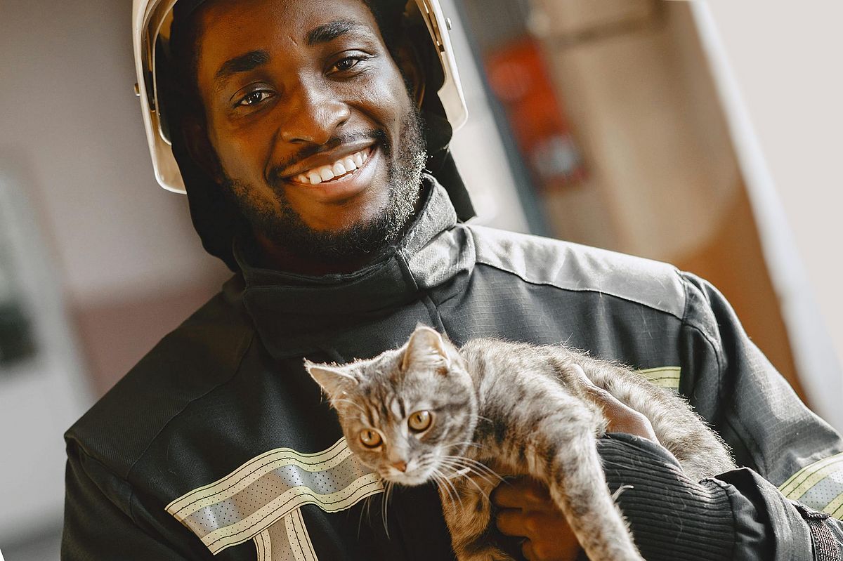 A fireman holding a cat.