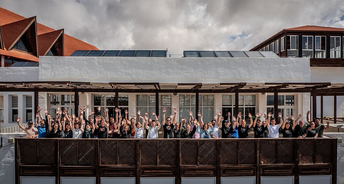 Group photo of TYPO3 Surfcamp attendees on the balcony of the venue in Fuerteventura.