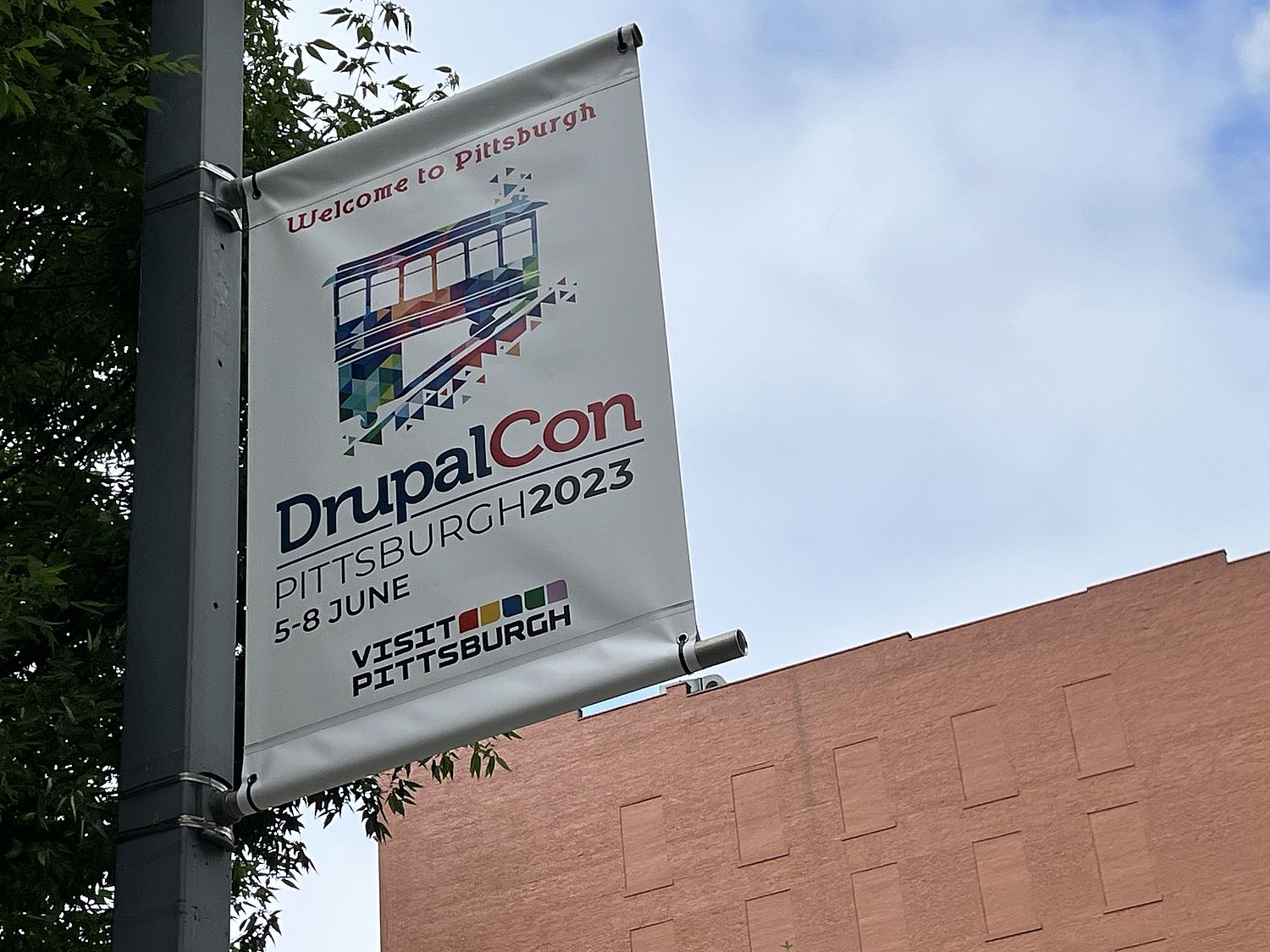 Lamp post banner featuring DrupalCon logo and info.