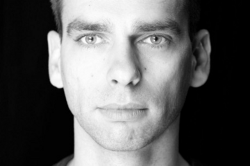 Grayscale portrait of a man, facing camera.
