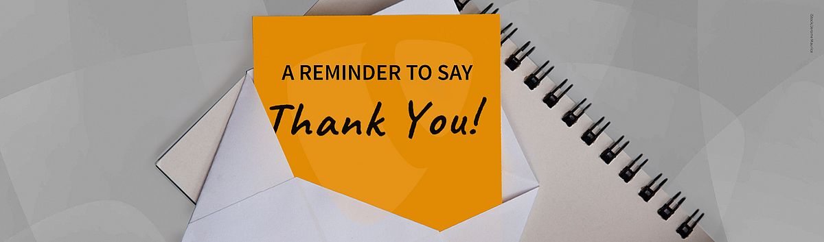 An envelope with an orange card inside reads "A Reminder to Say Thank You!" in black text, placed next to a spiral notebook.