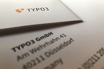 Printed paper showing the TYPO3 logo and the TYPO3 Gmbh address blurred.