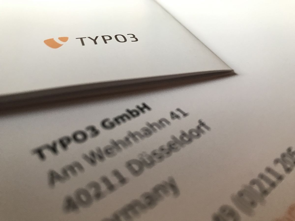 Printed paper showing the TYPO3 logo and the TYPO3 Gmbh address blurred.