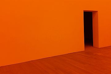 Orange floor and wall. Black door opening.